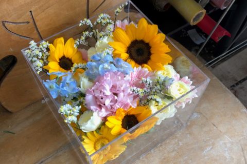 アクリルケースに納められた向日葵などの色とりどりの花々。