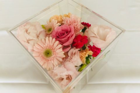 アクリルケースに納められたピンクの薔薇などの色とりどりの花々。