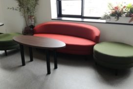 赤いソファと緑色のオットマンが置いてある待合室イメージ